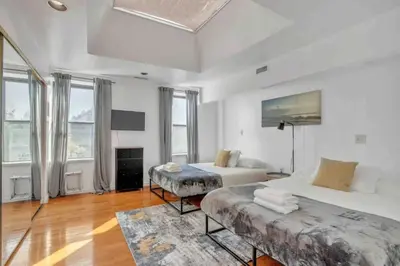 a large white room with two beds and windows at Large 3BR in Spring Garden in Philadelphia