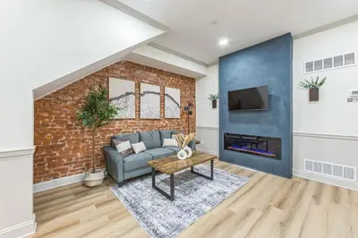 a living room with a couch and a brick wall at New 2BR Across from Fairmount Park - 10 mins to DT in Philadelphia