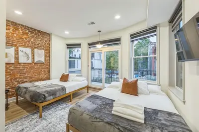 two beds in a room with a brick wall at New 2BR Across from Fairmount Park - 10 mins to DT in Philadelphia
