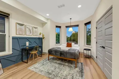 a bedroom with a bed and a desk and windows at New 2BR Across from Fairmount Park - 10 mins to DT in Philadelphia
