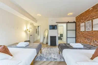 two beds in a room with a brick wall at New 2BR Across from Fairmount Park - 10 mins to DT in Philadelphia