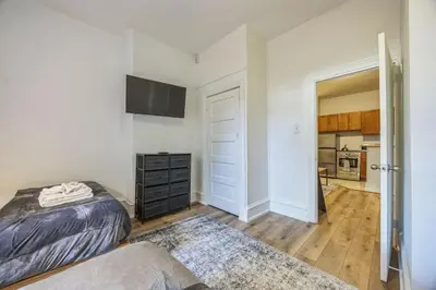 a bedroom with a bed and a dresser and a kitchen at Quaint and Cozy Center City 1BR that Sleeps 4 in Philadelphia