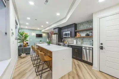 a kitchen with a white counter and chairs in it at Bi-Level 2BR w Rooftop - Sleeps 12 - 10 min to DT in Philadelphia