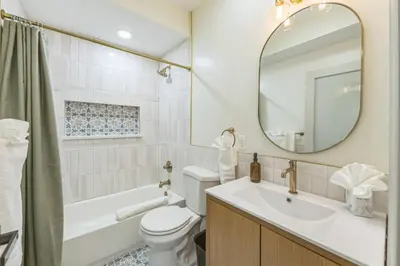 a bathroom with a sink and a toilet and a mirror at Bi-Level 2BR w Rooftop - Sleeps 12 - 10 min to DT in Philadelphia