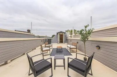 a patio with chairs and a table on a roof at Bi-Level 2BR w Rooftop - Sleeps 12 - 10 min to DT in Philadelphia
