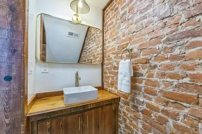 a bathroom with a sink and a brick wall at Bi-Level 2BR w Rooftop - Sleeps 12 - 10 min to DT in Philadelphia