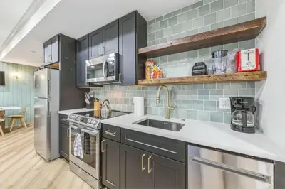 a kitchen with black cabinets and a sink at Bi-Level 2BR w Rooftop - Sleeps 12 - 10 min to DT in Philadelphia