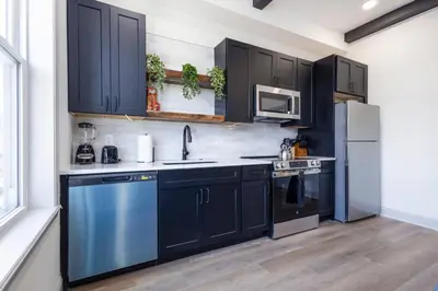 a kitchen with black cabinets and a blue dishwasher at 1BR Across from Fairmount Park - 10 mins to DT (E) in Philadelphia