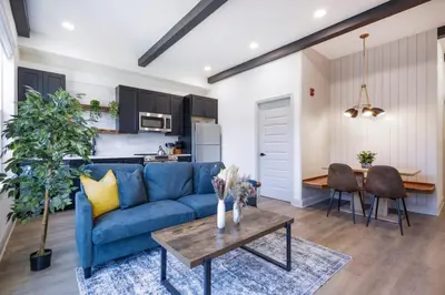 a living room with a blue couch and a table at 1BR Across from Fairmount Park - 10 mins to DT (E) in Philadelphia