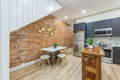 a kitchen with a brick wall and a table and chairs at New 2BR Across from Fairmount Park - 10 Mins to DT in Philadelphia