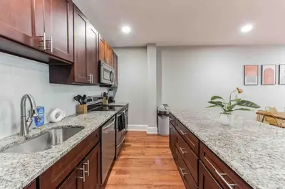 a kitchen with wooden cabinets and granite counter tops at NEW 4 Bedroom - 4 Bathroom Center City with Private Rooftop Terrace Sleeps 20) in Philadelphia