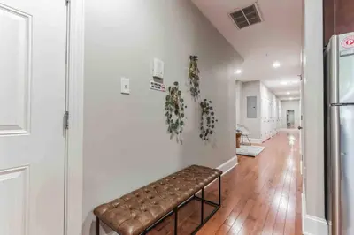 a brown leather bench in a room with a hallway at NEW 4 Bedroom - 4 Bathroom Center City with Private Rooftop Terrace Sleeps 20) in Philadelphia