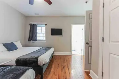a bedroom with two beds and a window and a door at NEW 4 Bedroom - 4 Bathroom Center City with Private Rooftop Terrace Sleeps 20) in Philadelphia