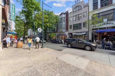 a busy city street with people walking on the sidewalk at NEW 4 Bedroom - 4 Bathroom Center City with Private Rooftop Terrace Sleeps 20) in Philadelphia