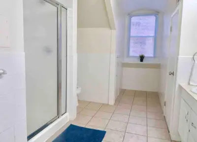 a bathroom with a shower and a toilet and a window at In the heart of Center City - Large bi-level 3BR in Philadelphia