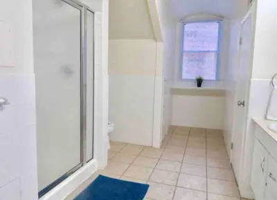 a bathroom with a shower and a blue rug at In the heart of Center City - Large bi-level 3BR in Philadelphia