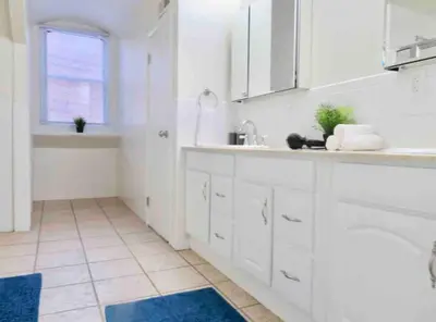 a white kitchen with a sink and a window at In the heart of Center City - Large bi-level 3BR in Philadelphia