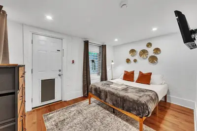 a white bedroom with a bed and a television at Cozy Center City 1BR apartment with Patio in Philadelphia