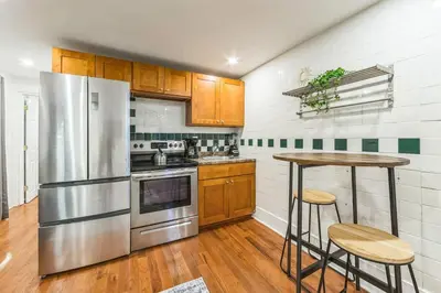 a kitchen with a stainless steel refrigerator and a table at Cozy Center City 1BR apartment with Patio in Philadelphia