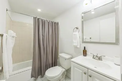 a bathroom with a toilet and a sink and a mirror at Cozy Center City 1BR apartment with Patio in Philadelphia