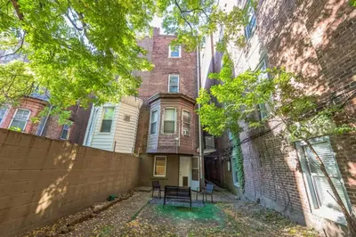 a house with two chairs in front of a building at Cozy Center City 1BR apartment with Patio in Philadelphia
