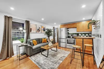 a living room with a couch and a kitchen at Cozy Center City 1BR apartment with Patio in Philadelphia