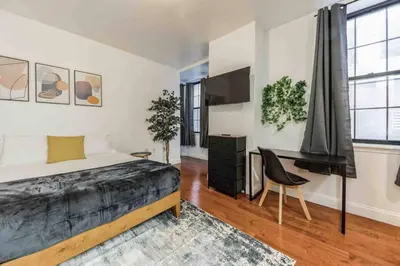 a bedroom with a bed and a desk and a chair at Studio Across the Street from Convention Center 2R in Philadelphia