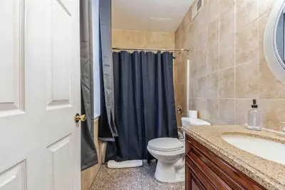 a bathroom with a toilet and a blue shower curtain at Studio Across the Street from Convention Center 2R in Philadelphia