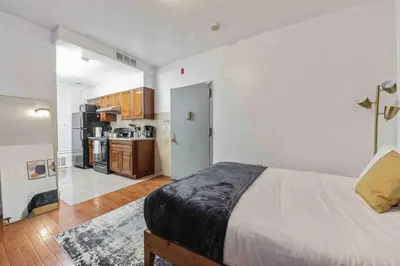 a bedroom with a large bed and a kitchen at Studio Across the Street from Convention Center 2R in Philadelphia
