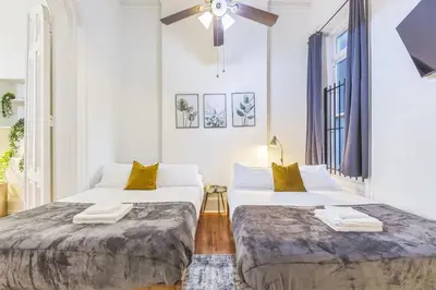 two beds in a white room with a ceiling fan at Large Historical Center City 1BR that Sleeps 4 in Philadelphia