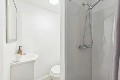 a white bathroom with a shower and a toilet at Large Historical Center City 1BR that Sleeps 4 in Philadelphia