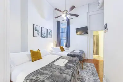 a white room with two beds and a ceiling fan at Large Historical Center City 1BR that Sleeps 4 in Philadelphia