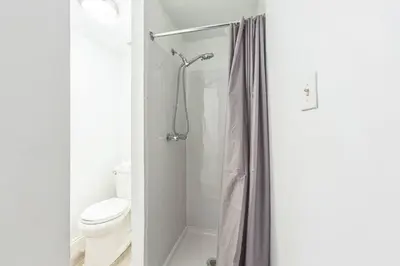 a white bathroom with a toilet and a shower at Large Historical Center City 1BR that Sleeps 4 in Philadelphia