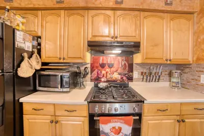 a kitchen with a stove and a microwave at 1mi to Lake Wallenpaupack | Firepit | Pet Friendly in Greentown