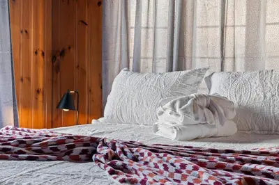 a bed with a blanket and pillows on it at Historic Tacony Retreat with Sauna in Philadelphia