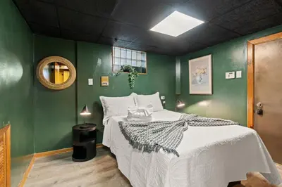 a bedroom with a large bed with green walls at Historic Tacony Retreat with Sauna in Philadelphia