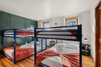 two bunk beds in a room with green walls at Historic Tacony Retreat with Sauna in Philadelphia