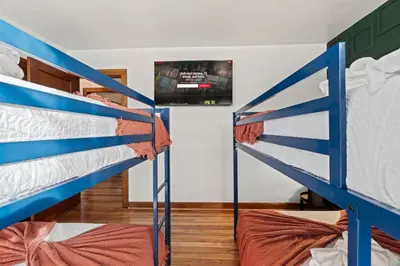 two bunk beds in a room with a tv at Historic Tacony Retreat with Sauna in Philadelphia