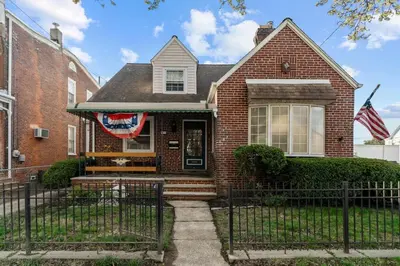 a house with a flag on the front of it at Historic Tacony Retreat with Sauna in Philadelphia