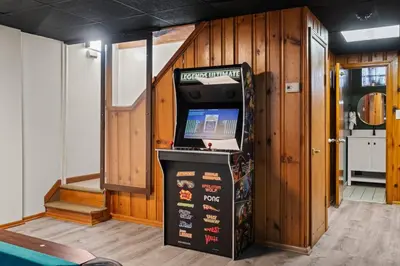 a video game machine in a room with wooden walls at Historic Tacony Retreat with Sauna in Philadelphia