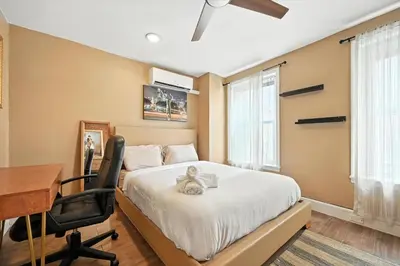 a bedroom with a desk and a bed with a teddy bear on it at Charming Home in Vibrant Philadelphia in Philadelphia