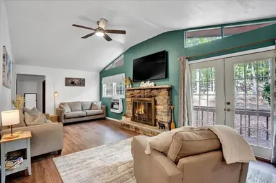 a living room with a fireplace and a flat screen tv at Tranquil Trails Cottage Fire Pit Cozy 3BDR in Gouldsboro