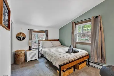 a bedroom with a bed and a window at Tranquil Trails Cottage Fire Pit Cozy 3BDR in Gouldsboro