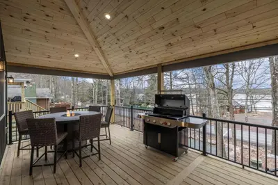 a screened in deck with a grill and a table and chairs at New Lakeview Gateway Lake Access, Hot tub, EV in Lake Harmony