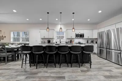 a kitchen with a bar with black chairs in it at New Lakeview Gateway Lake Access, Hot tub, EV in Lake Harmony