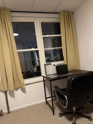a desk with a laptop and a chair in front of a window at Cozy Comfy with AMAZING NYC Views 15min to Manhattan T SQ in Union City