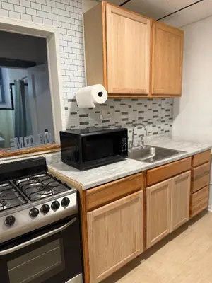 a kitchen with a stove and a sink and a microwave at Cozy Comfy with AMAZING NYC Views 15min to Manhattan T SQ in Union City