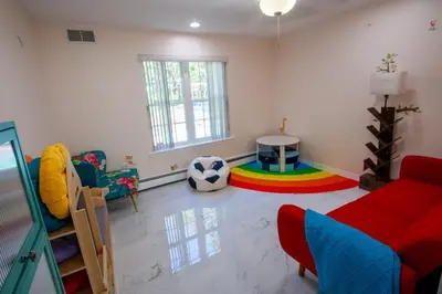 a living room with a red couch and a soccer ball at Huge Pocono Dreamhouse 4 bedrooms 12 guests in Blakeslee