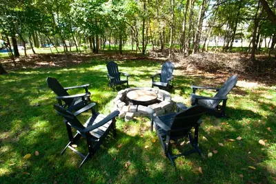 a group of chairs and a table in the grass at Huge Pocono Dreamhouse 4 bedrooms 12 guests in Blakeslee