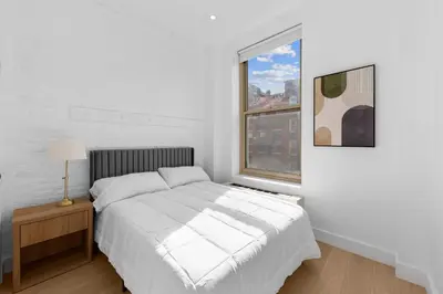 a white bedroom with a bed and a window at 19-5D 2BR 2Baths Luxury Apt East Village in New York